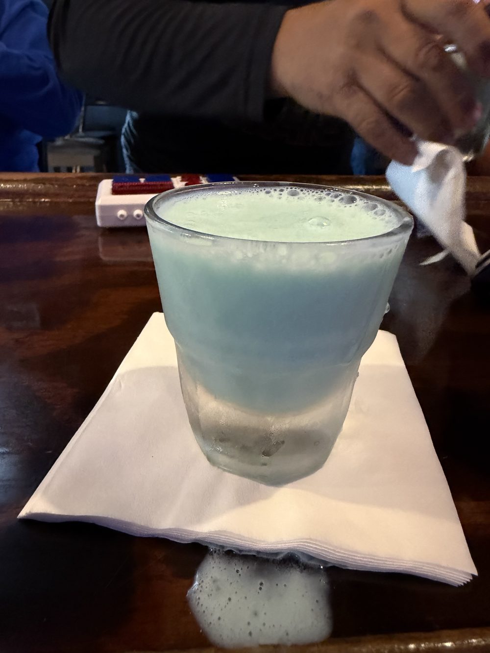 Frosty blue cocktail on a napkin at the bar