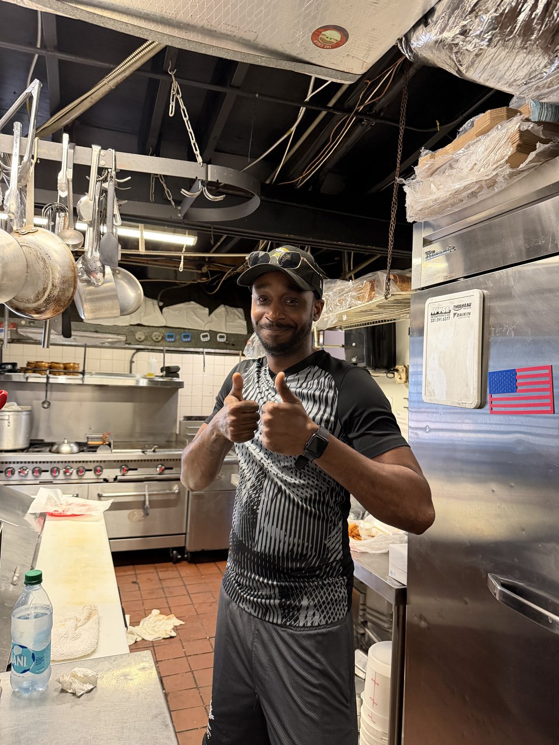 Kelly's cook giving a double thumbs up in the kitchen