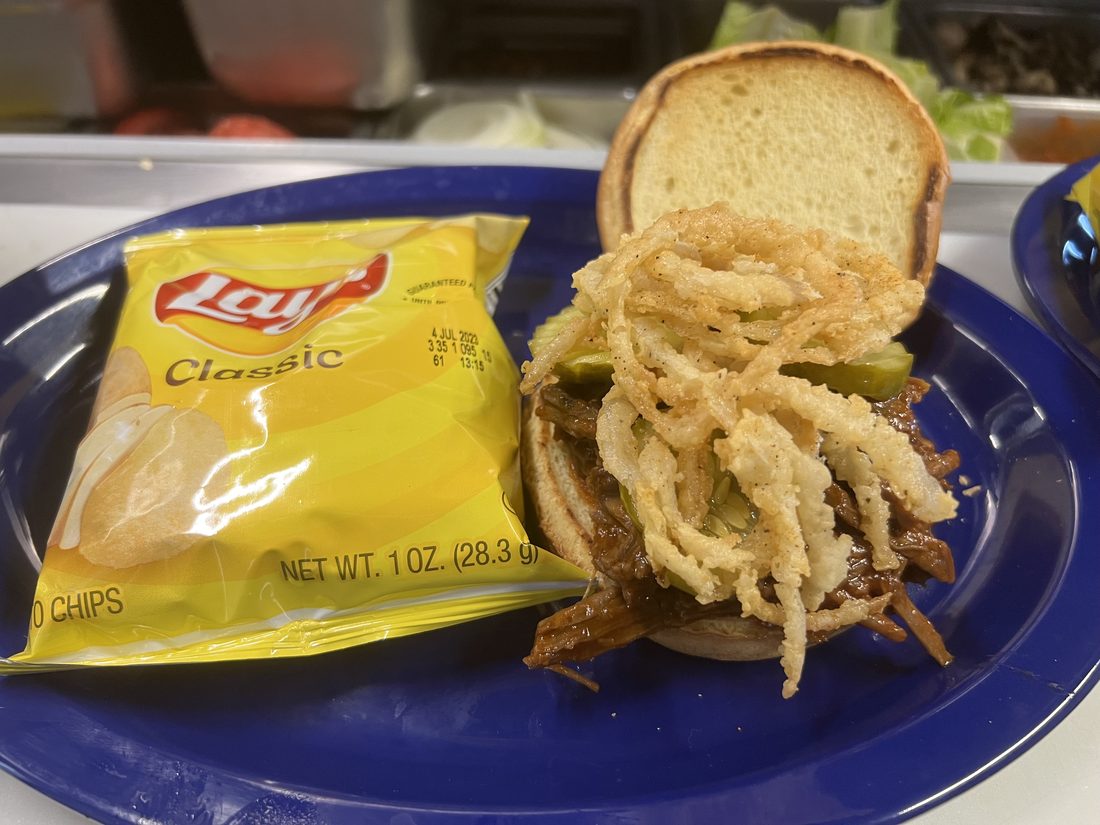BBQ pulled pork sandwich piled with crispy onion straws